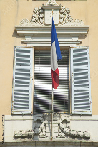 French flag flying from window, Antibes, France photo