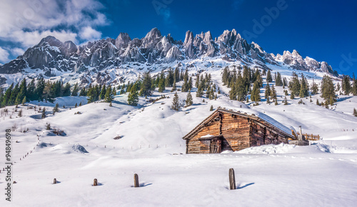 Idyllic winter wonderland scenery with traditional mountain chalet in the Alps