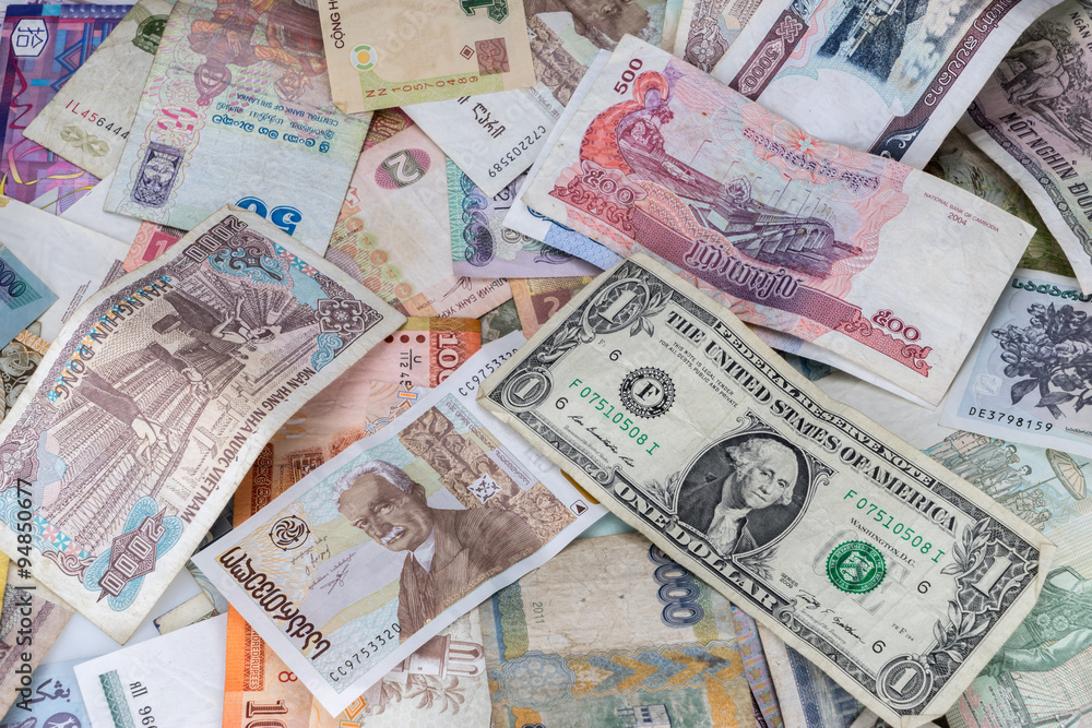 Many banknotes of different countries scattered on the table