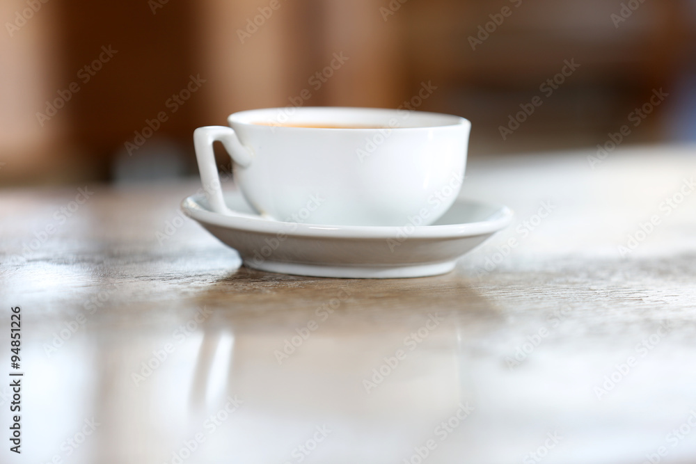 Cup of coffee in the table on defocused background