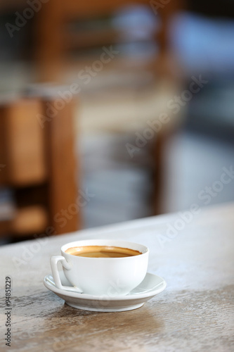 Cup of coffee in the table on defocused background