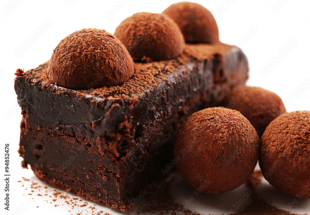 Slice of chocolate cake with a truffle on plate closeup Slice of chocolate cake with a truffle on plate closeup
