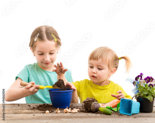 Two little sisters are engaged in gardening