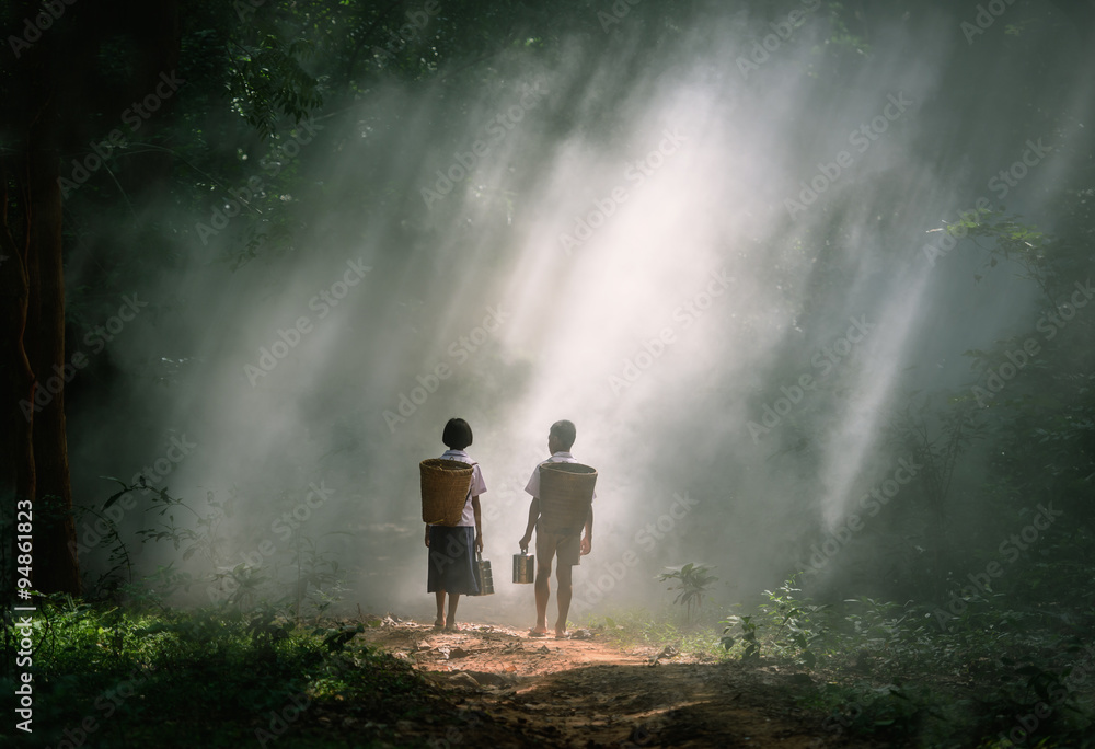 Boy and Girl go hiking on a forest road, Thailand