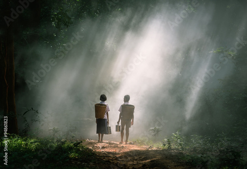 Boy and Girl go hiking on a forest road, Thailand