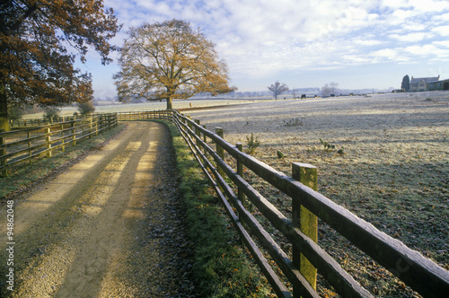 Morning view of a country road and wood fence in Upper Brails, England