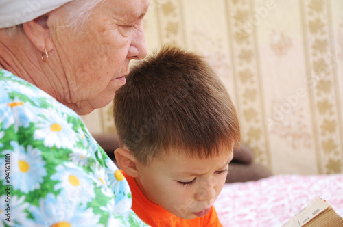 Canvastavla Grandmother and grandson looking at the book