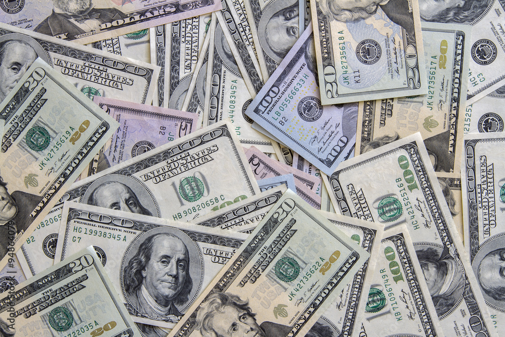 A pile of  US dollar bills on a table pile as background.
