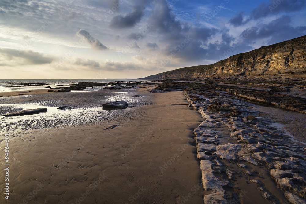 Stunning vibrant sunset landscape over Dunraven Bay in Wales