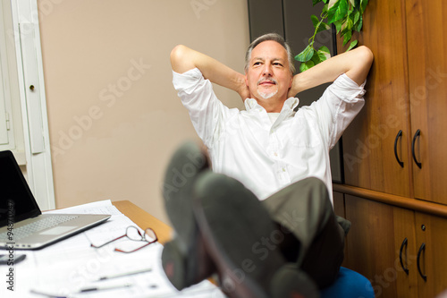 Businessman relaxing at the office with his shoes on the desk