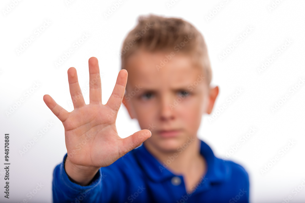 Boy with raised hand making stop gesture Boy with raised hand making stop gesture