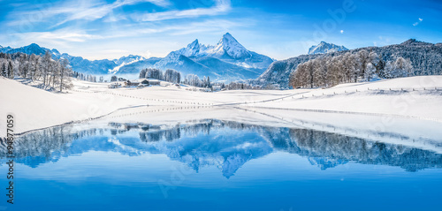 Winter wonderland in the Alps reflecting in crystal clear mountain lake