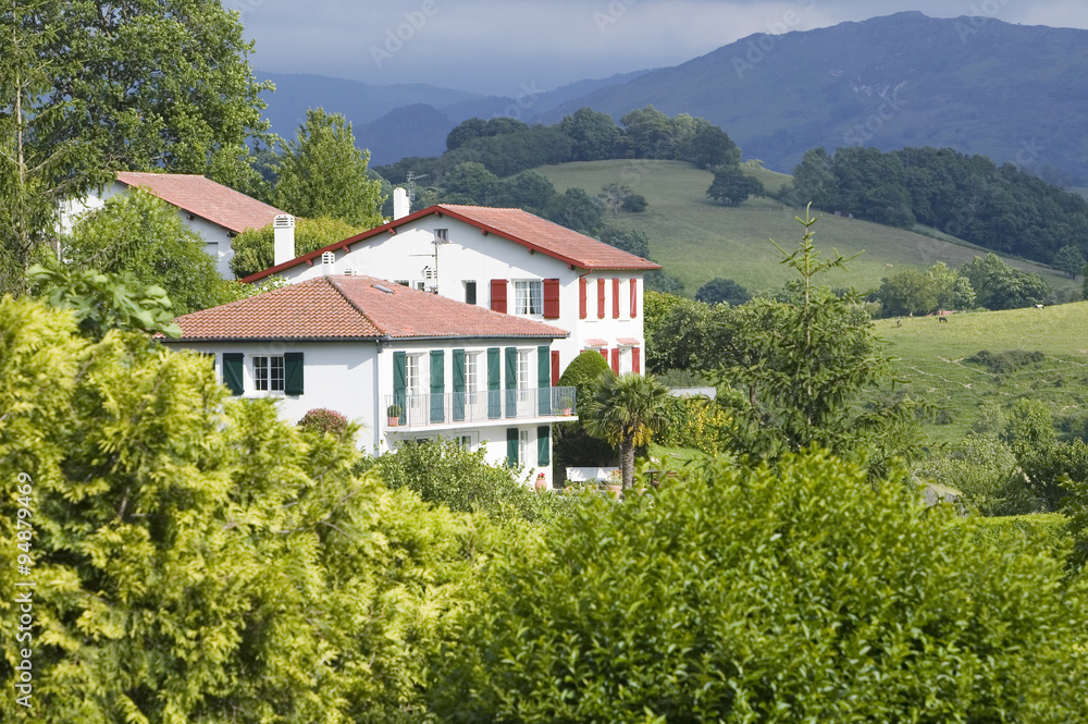 Sare, France in Basque Country on Spanish-French border, is a hilltop 17th century village surrounded by farm fields and mount Rhune in the Labourd province. The houses are built in the traditional style of the region, with shutters painted colors red and green of the Basque flag. Close to St. Jean de Luz, on the Cote Basque, France. Sare, France in Basque Country on Spanish-French border, is a hilltop 17th century village surrounded by farm fields and mount Rhune in the Labourd province. The houses are built in the traditional style of the region, with shutters painted colors red and green of the Basque flag. Close to St. Jean de Luz, on the Cote Basque, France.