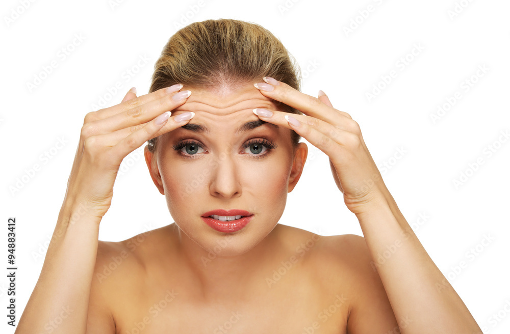 Fototapeta premium A young woman checking wrinkles on her forehead