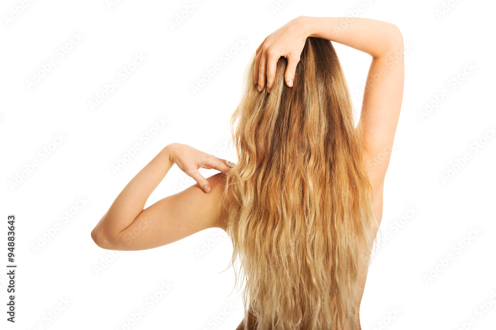 Fototapeta premium Back view of naked woman touching her shoulder