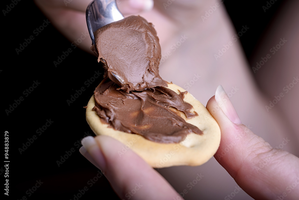biscuit and chocolate cream in female hand with spoon biscuit and chocolate cream in female hand with spoon