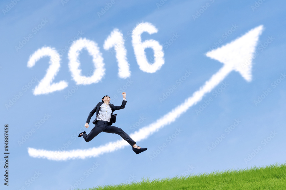 Worker jumps with numbers 2016 and upward arrow in sky Worker jumps with numbers 2016 and upward arrow in sky