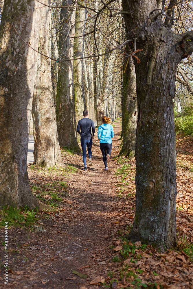 Young running couple jogging in autumn nature