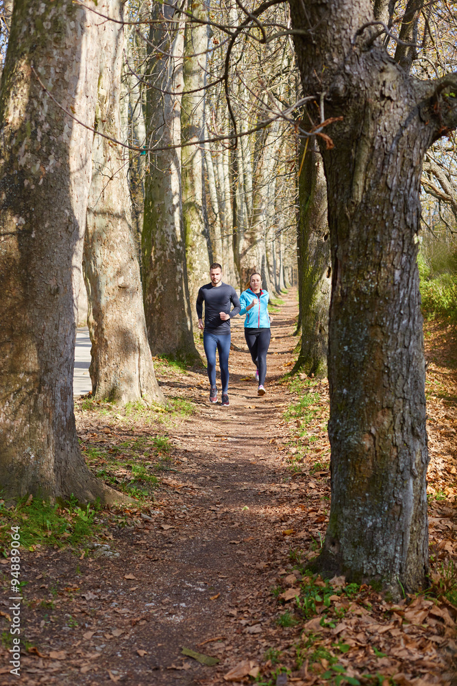 Obraz premium Young running couple jogging in autumn nature