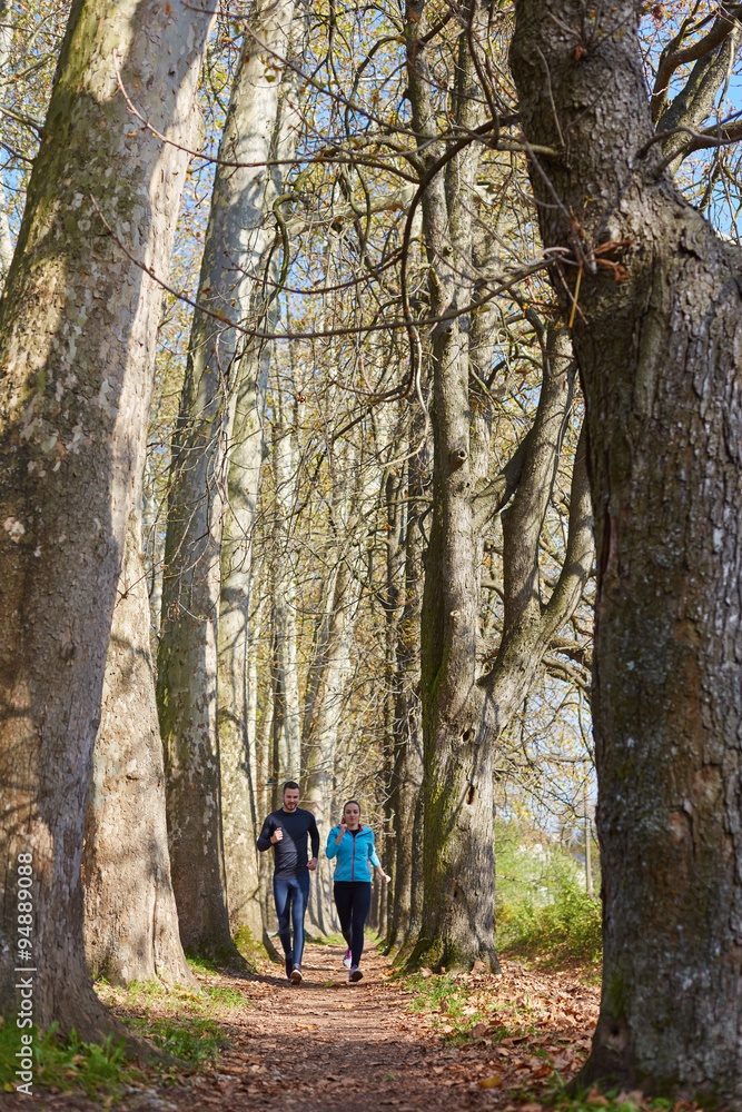 Young running couple jogging in autumn nature Young running couple jogging in autumn nature