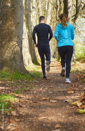 Young running couple jogging in autumn nature