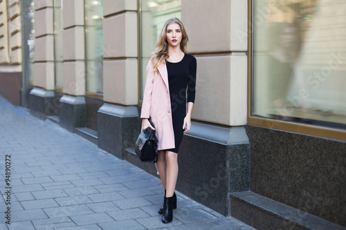 Young beautiful woman standing on the street. Elegant outfit. Full body portrait. Female fashion.