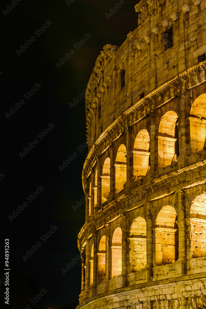 Artistic detail of the lit Colosseum in Rome, Italy at night