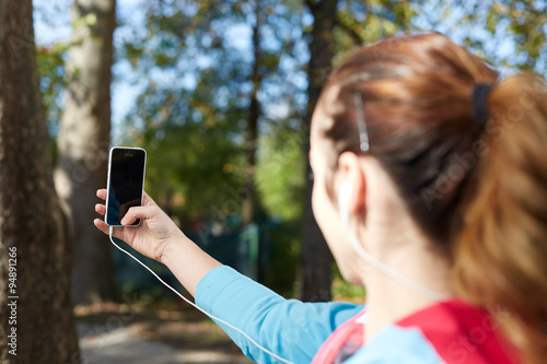 Young Sporty Woman Taking a Selfie at Park. She is Looking at Sm
