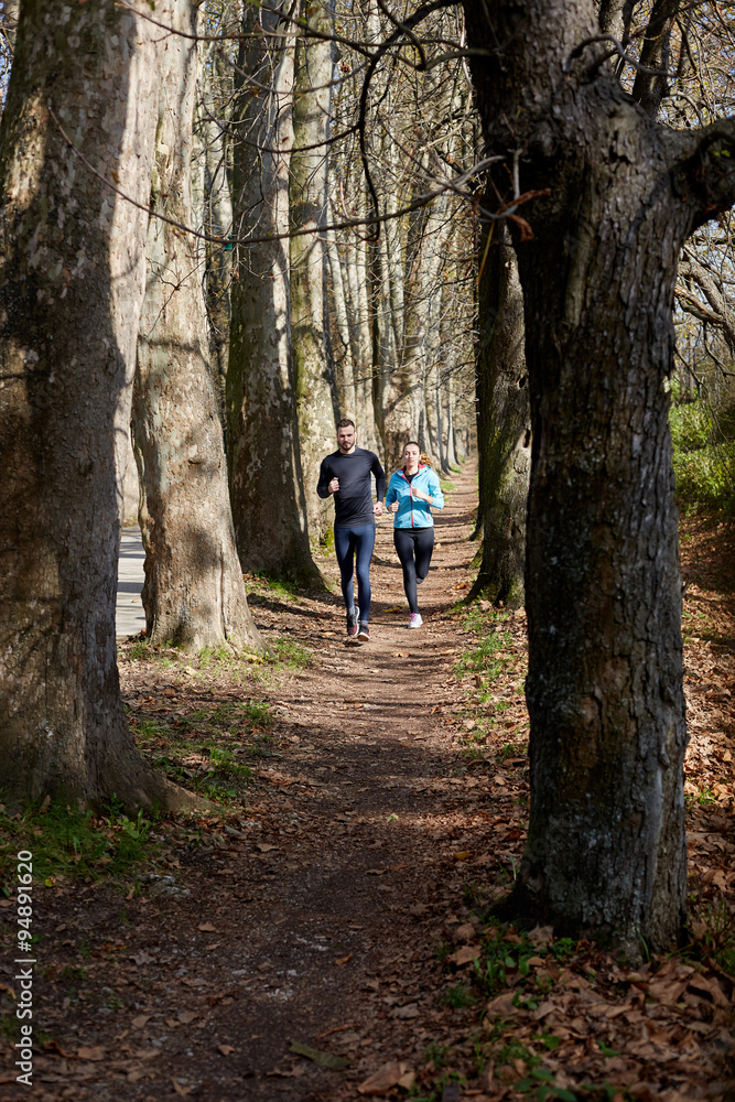 Fototapeta premium Young couple running together in park - fall nature