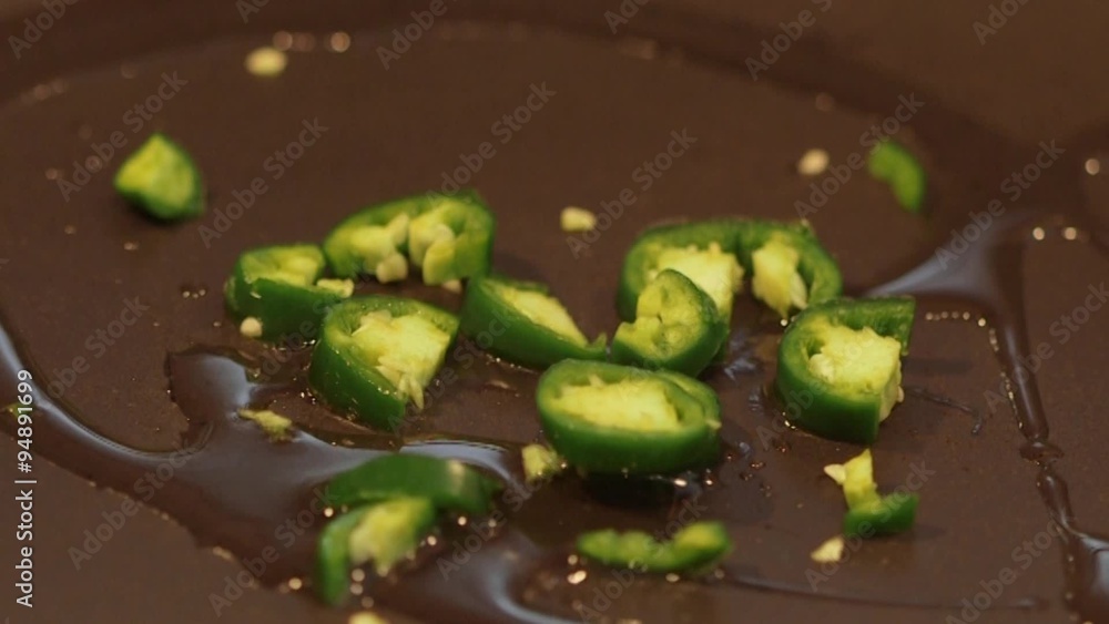 Sauteed jalapeno peppers cooking on stovetop frying pan Stock Video