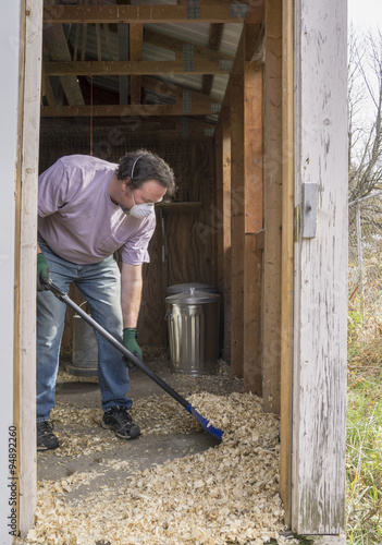 Chicken Farmer Cleaning A Coop Out