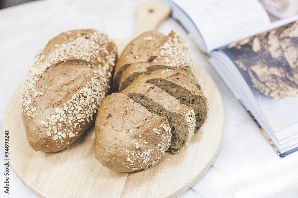Naklejka premium slices of freshly baked multigrain bread on rustic background, square image