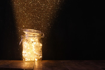 low key and vintage filtered image of fairy lights in mason jar with. selective focus.
