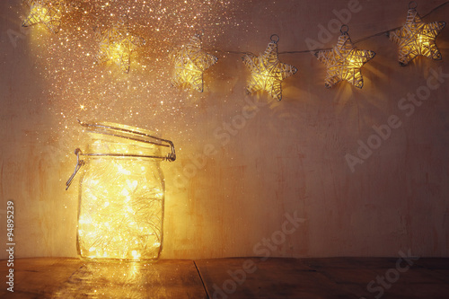 Foto low key and vintage filtered image of fairy lights in mason jar with