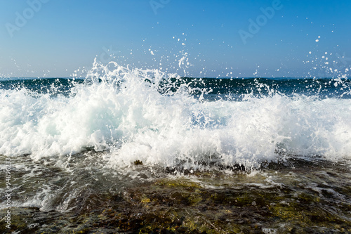 Waves breaking on a stony beach, forming sprays