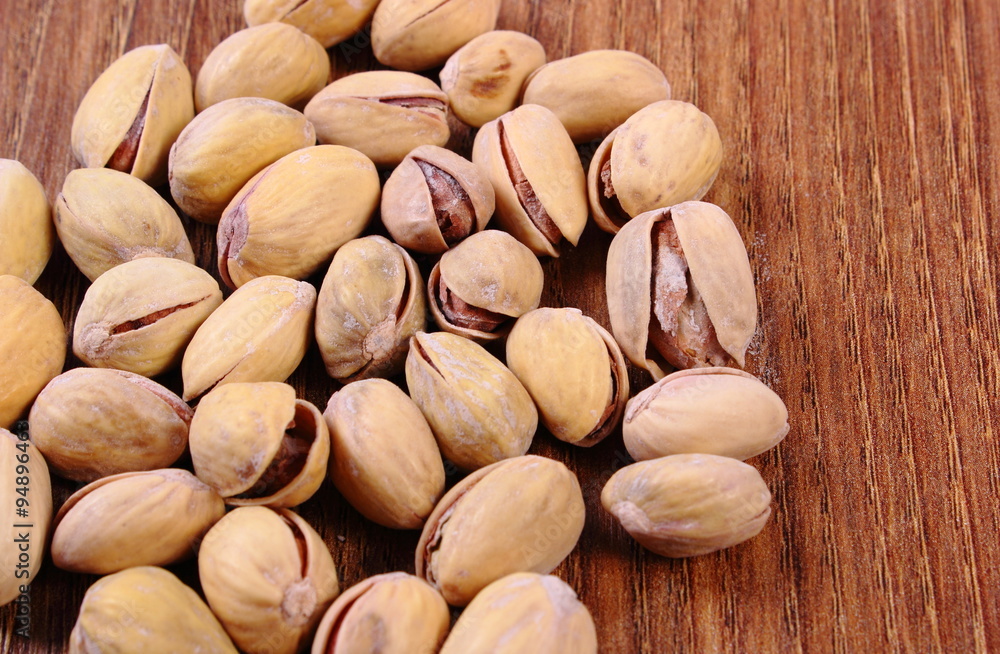 Pistachio nuts on wooden table, healthy eating