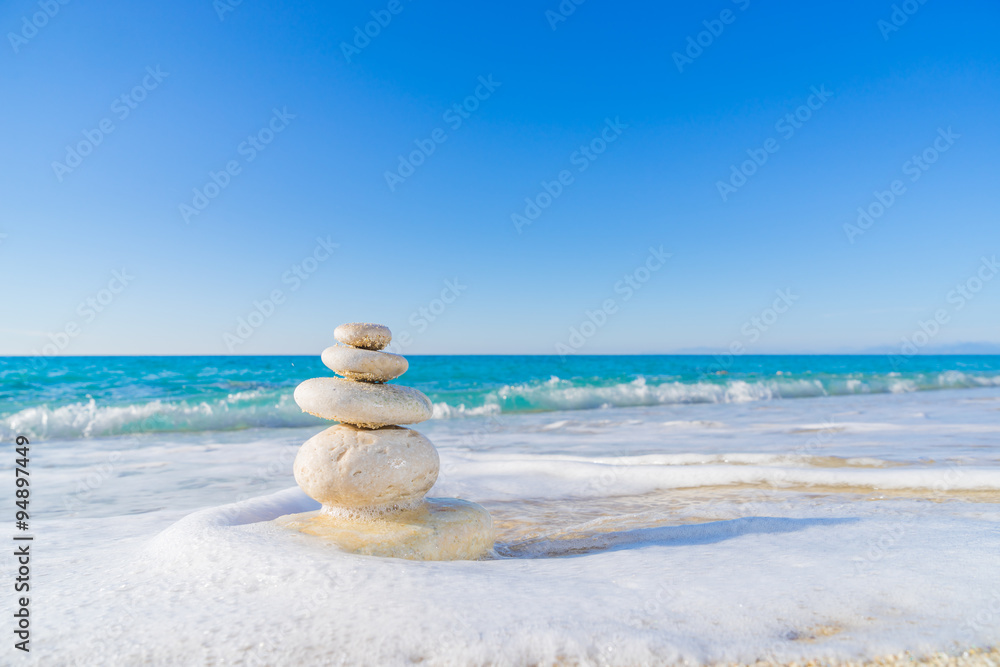 Stones pyramid on sand symbolizing zen, harmony, balance. Ocean