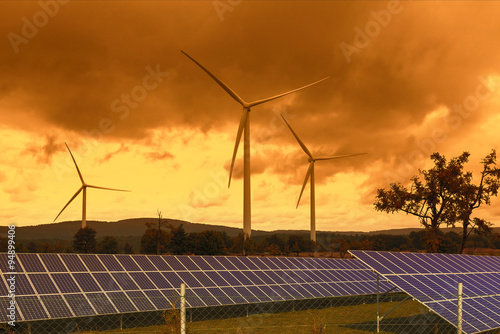 Wind turbines with solar panels in the sunset