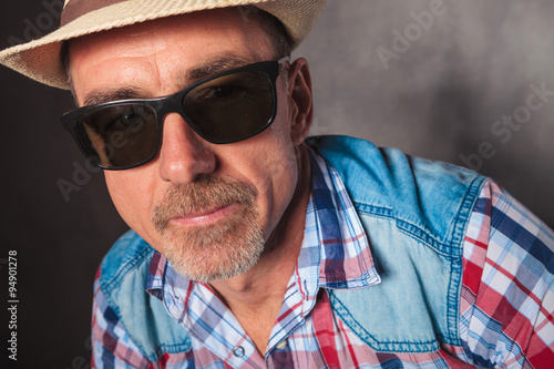 head and shoulders of  mature man wearing hat and sunglasses