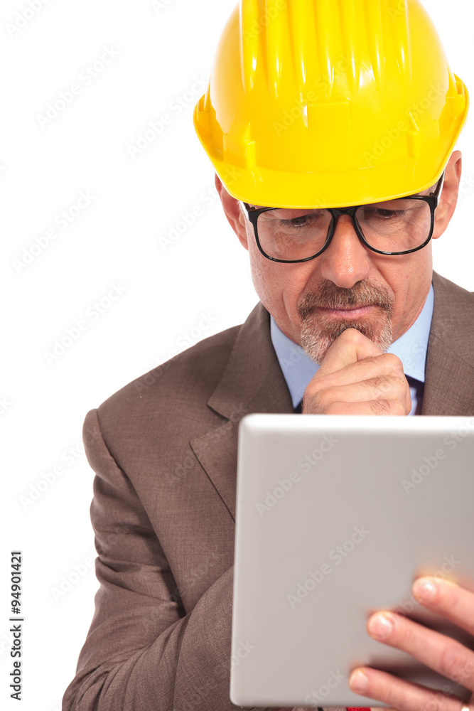 thoughtful construction engineer reading on his tablet pad thoughtful construction engineer reading on his tablet pad