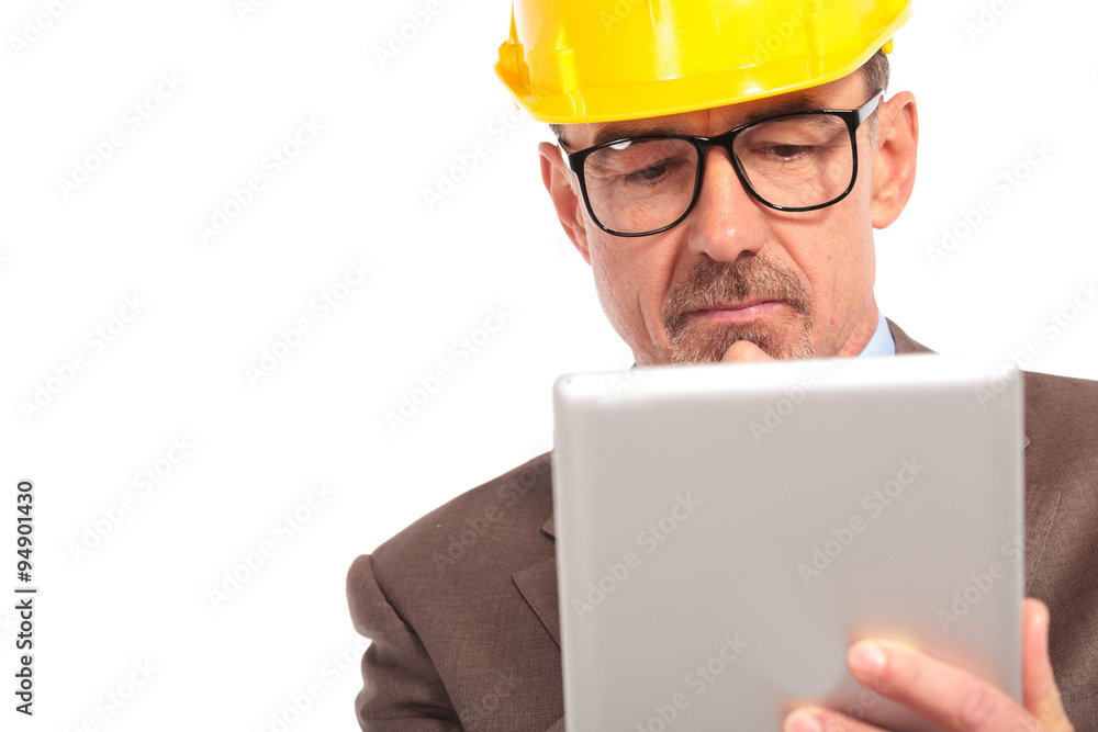 concerned senior construction engineer reading on his tablet concerned senior construction engineer reading on his tablet