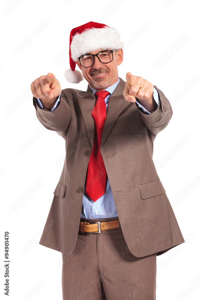happy aged businessman wearing santa claus cap pointing his fing happy aged businessman wearing santa claus cap pointing his fing
