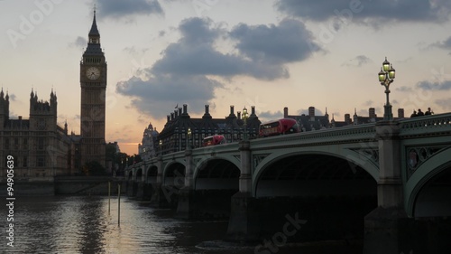  London buses cross Westminster Bridge at Sunset, stopping at Parliament. Shot in 4K photo
