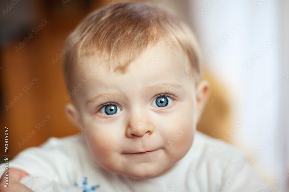 Baby with blue eyes looking at camera, indoors