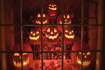 Halloween display of glowing jack-o-lanterns in a store window at night, Connecticut.