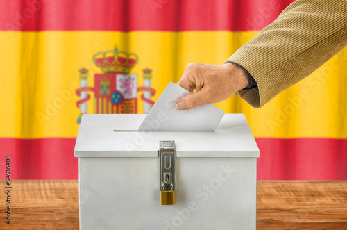 Mann wirft Stimmzettel in Wahlurne - Spanien photo