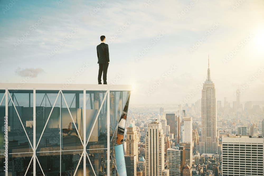 Businessman on the top of skyscraper looking at the city Businessman on the top of skyscraper looking at the city