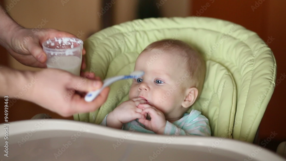 smiling baby eating food on kitchen in his chair smiling baby eating food on kitchen in his chair