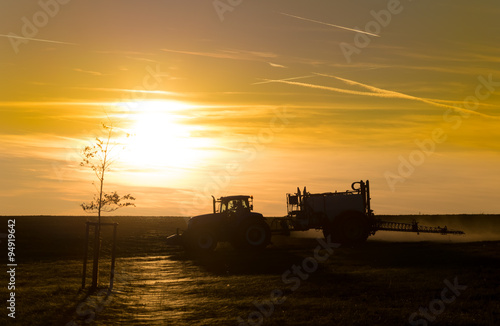 Sunset over a field with tractor