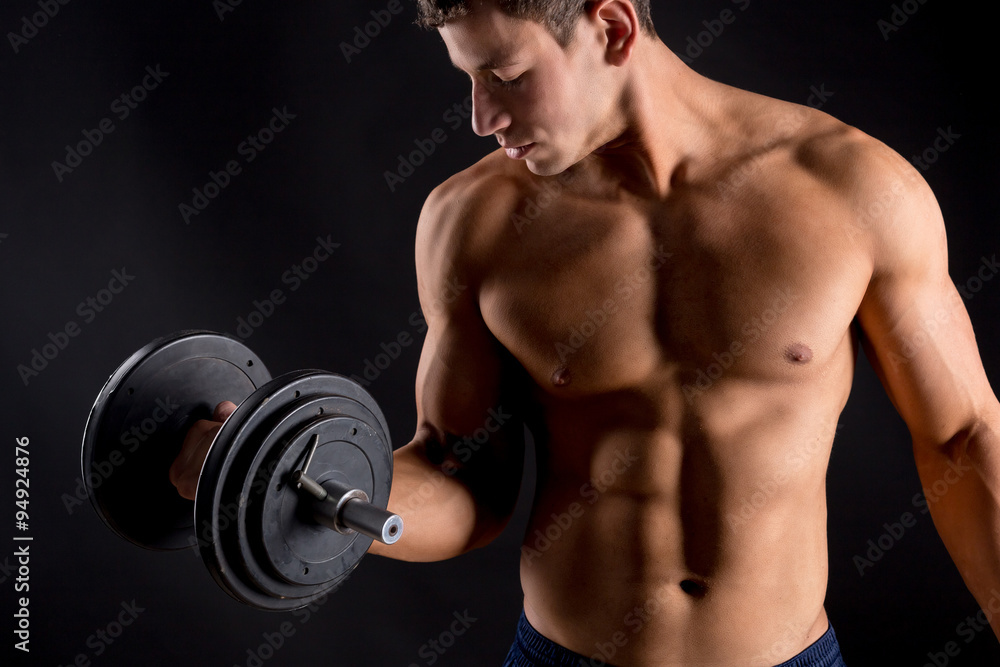Strong athletic man on black background
